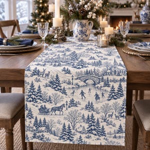 Puede incluir: Un camino de mesa rectangular con un patrón toile de jouy en azul y blanco que representa un paisaje invernal con árboles nevados, un puente de piedra, un trineo tirado por caballos, patinadores sobre hielo y una iglesia.