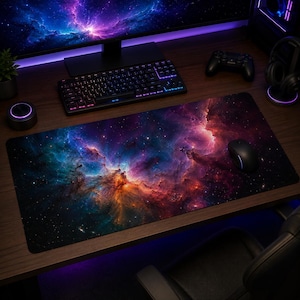 Puede incluir: Una alfombrilla de escritorio rectangular con un estampado de nebulosa vibrante que muestra nubes arremolinadas de colores púrpura, azul, naranja y rojo sobre un fondo oscuro estrellado. La alfombrilla tiene una superficie lisa y está sobre un escritorio.