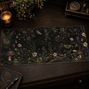 May include: A rectangular desk mat featuring a dark, detailed botanical illustration of a forest floor at night. The design includes various mushrooms, ferns, wildflowers, and moths set against a deep black background with subtle glowing elements.
