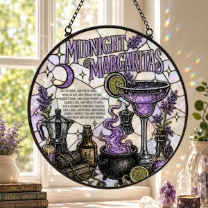 May include: A circular stained glass suncatcher featuring the text Midnight Margaritas, a purple cocktail, a cauldron with swirling smoke, a coffee pot, and a skull-labeled bottle. The design includes lavender sprigs and a crescent moon.