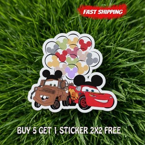May include: A white sticker featuring cartoon images of Mater and Lightning McQueen from the movie Cars. The sticker also includes a cluster of Mickey Mouse head shapes in various colours and the text "BUY 5 GET 1 STICKER 2X2 FREE".