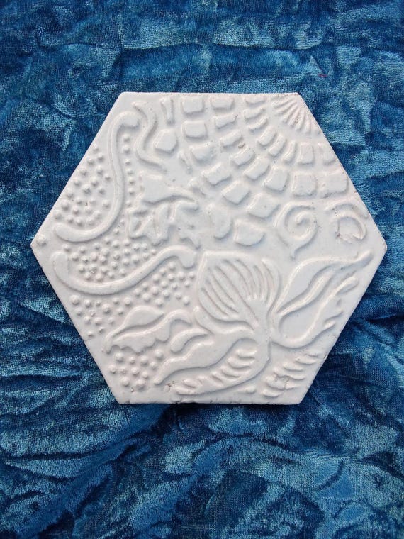 Hand-pressed hexagon ceramic tiles with raised relief texture — a genuinely artisan backsplash tile you can't get at Home Depot.