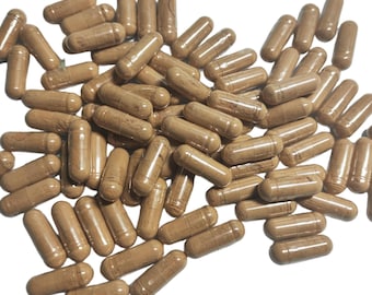 May include: A collection of brown capsules with a translucent, cylindrical form. The capsules are spread across a white surface, with some overlapping. The capsules appear to be filled with a light brown powder.