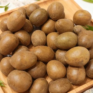 May include: A wooden tray filled with numerous brown, oval-shaped fruits. The fruits have a smooth skin and vary slightly in color, ranging from light to dark brown. The arrangement suggests a harvest or display of fresh produce.