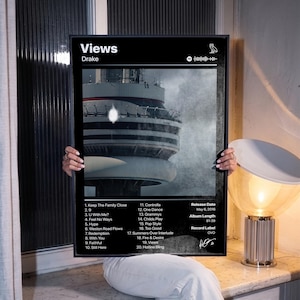 Könnte beinhalten: Ein gerahmtes schwarz-weiß Poster des Albums Views von Drake. Das Design zeigt ein zentrales Bild des CN Towers, eine Titelliste von 1 bis 20, das Veröffentlichungsdatum 6. Mai 2016, die Albumlänge 81:39 und das Plattenlabel OVO.