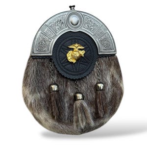 K&ouml;nnte beinhalten: Ein traditioneller schottischer Sporran mit silbernem Cantle und Fellk&ouml;rper. Der Cantle weist komplizierte keltische Knotenmuster und ein zentrales Emblem auf. Drei Quasten h&auml;ngen von unten und tragen zur dekorativen Ausstrahlung des Sporrans bei.