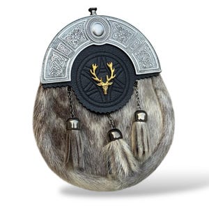 K&ouml;nnte beinhalten: Ein traditioneller schottischer Sporran mit silbernem Cantle und einer schwarzen Lederklappe mit einem goldenen Hirsch-Emblem. Der Sporran hat einen Pelzk&ouml;rper und drei dekorative Quasten.