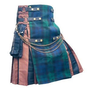 Peut inclure: Un kilt à carreaux bleus et verts, avec des panneaux marron et noirs. Il comporte des sangles noires avec des clous dorés, une chaîne dorée et une petite poche noire. Vêtement traditionnel.