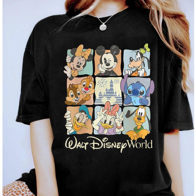 Puede incluir: Camiseta negra con una cuadr&iacute;cula de personajes de Disney, incluyendo Mickey y Minnie Mouse, Goofy, Donald y Daisy Duck, Chip y Chop y Stitch. Las palabras "Walt Disney World" est&aacute;n impresas en amarillo.