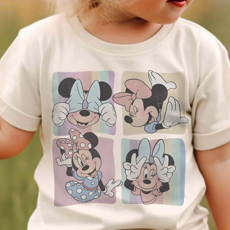 May include: Cream-colored t-shirt featuring a colorful Minnie Mouse graphic. The graphic is divided into four squares, each showcasing a different pose of Minnie Mouse. The background has pastel stripes.