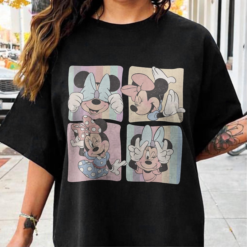 May include: Black t-shirt featuring a four-panel design of Minnie Mouse in various poses. Each panel has a pastel background with vertical stripes. Minnie is wearing different colored bows and outfits in each panel.
