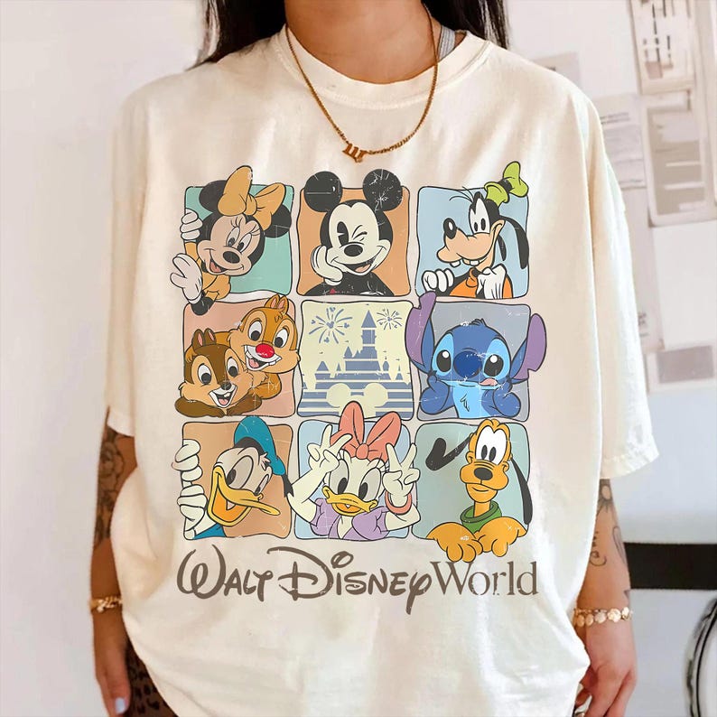 Puede incluir: Camiseta color crema con una cuadr&iacute;cula de personajes de Disney, incluyendo Mickey Mouse, Minnie Mouse, Goofy, Donald Duck, Daisy Duck, Chip y Chop, Stitch y Pluto. Las palabras "Walt Disney World" est&aacute;n impresas en la parte inferior.