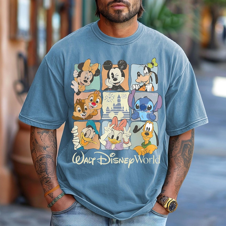 Puede incluir: Camiseta azul claro de manga corta con una cuadr&iacute;cula de personajes de Disney, incluyendo Mickey Mouse, Minnie Mouse, Goofy, Donald, Daisy, Chip y Chop, Stitch y Pluto. Las palabras "Walt Disney World" est&aacute;n impresas en blanco debajo.