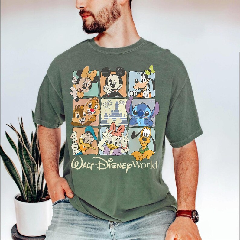 Puede incluir: Camiseta verde con un dise&ntilde;o de cuadr&iacute;cula que muestra personajes de Disney como Mickey Mouse, Minnie Mouse, Donald Duck y Stitch. Las palabras "Walt Disney World" est&aacute;n impresas debajo. La camiseta es de color verde liso.