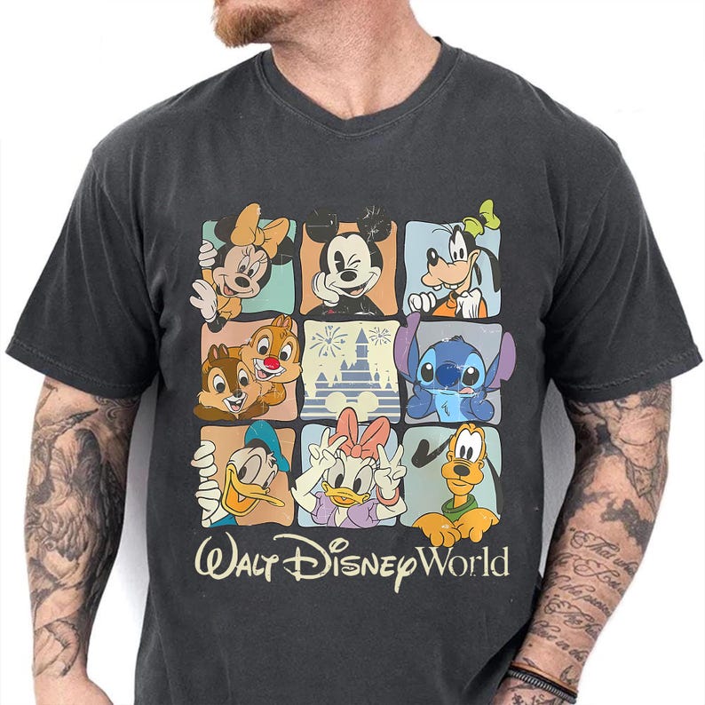 Puede incluir: Camiseta gris oscuro con cuello en V que presenta una colorida cuadr&iacute;cula de personajes de Disney, incluyendo Mickey Mouse, Minnie Mouse, Goofy, Donald, Daisy, Chip y Chop, Stitch y Pluto. Las palabras "Walt Disney World" est&aacute;n impresas debajo.