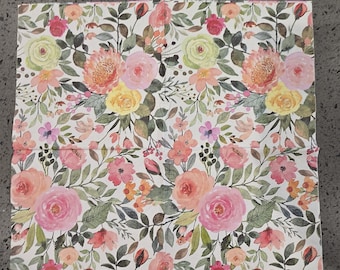 Puede incluir: Una caja cuadrada con un estampado floral. El diseño presenta flores rosas, melocotón, amarillas y rojas con hojas verdes sobre un fondo blanco. La caja probablemente esté hecha de papel o cartón.
