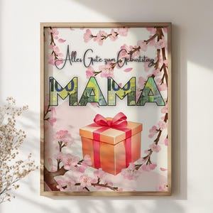 May include: A framed print with the word "MAMA" in large, colorful letters, and the text "Alles Gute zum Geburtstag". The print features a watercolor illustration of a gift box with a red bow, surrounded by pink cherry blossoms.