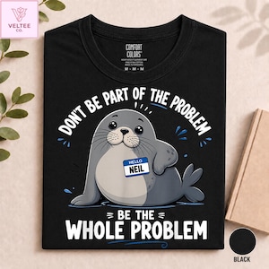 Könnte beinhalten: Ein schwarzes T-Shirt mit einer Grafik eines grauen Seehunds, der ein Namensschild mit der Aufschrift HELLO NEIL trägt. Der Text über dem Seehund lautet DON'T BE PART OF THE PROBLEM und darunter steht BE THE WHOLE PROBLEM in weißen Großbuchstaben.