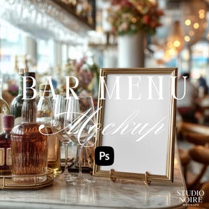May include: A gold-framed menu mockup stands on a marble surface, with the words "BAR MENU Mockup" overlaid. Wine glasses and bottles of liquor are in the background. The image has a soft focus, suggesting a bar or restaurant setting.