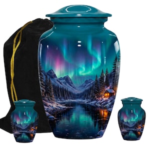May include: Teal cremation urn with a matching keepsake urn and a black velvet bag. The urns feature a scenic landscape with a lake, mountains, and the aurora borealis. The urns are made of metal.