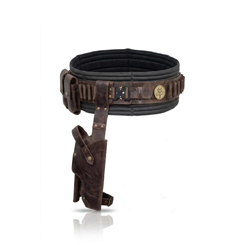 Puede incluir: Un cintur&oacute;n utilitario de cuero marr&oacute;n oscuro con forro interior negro acolchado, hebilla met&aacute;lica, funda lateral y un peque&ntilde;o bolsillo. El cintur&oacute;n incluye un emblema circular dorado en la parte frontal y m&uacute;ltiples trabillas de sujeci&oacute;n.