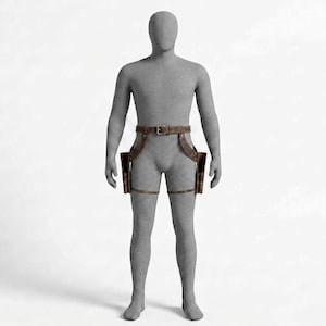 May include: A brown leather dual holster belt system worn on a grey mannequin. The accessory features a waist belt with a metal buckle, two side holsters positioned at the hips, and adjustable leg straps that secure around each thigh for stability.