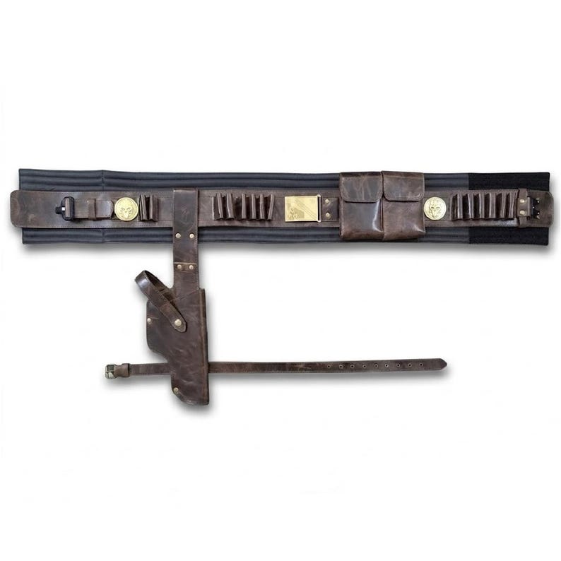 Puede incluir: Un cintur&oacute;n utilitario de cuero marr&oacute;n oscuro con una base de tela negra, m&uacute;ltiples presillas para objetos peque&ntilde;os, una hebilla rectangular dorada, dos bolsas peque&ntilde;as y dos emblemas circulares dorados. Una funda de cuero a juego cuelga del cintur&oacute;n.