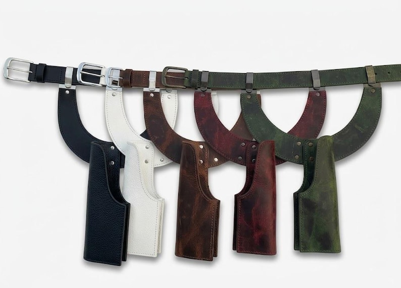 May include: A collection of five leather utility belts, each featuring a curved holster attachment. The belts are available in black, white, brown, dark red, and olive green, all equipped with matching metal buckles and hardware fasteners.