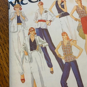 May include: A sewing pattern envelope featuring illustrations of various outfits including blazers, trousers, skirts, and sleeveless tops. The figures are depicted in diverse combinations of white, navy blue, and plaid garments with red accents.