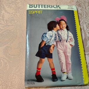 May include: A vintage Butterick sewing pattern featuring two children in Esprit clothing. The cover shows a boy kissing a girl on the cheek. The pattern includes the Esprit logo and the text "Pattern Patron".