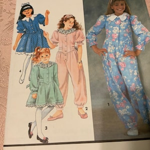 May include: A sewing pattern for children's clothing. The pattern includes three different styles: a blue dress with white polka dots, a pink jumpsuit with puffed sleeves, and a blue and white floral print dress. The pattern is numbered 1, 2, 3, and 4.