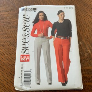 May include: A sewing pattern package featuring two women modeling pants and tops. One woman wears a red turtleneck and gray pants, the other a black top and orange pants. The package has the text "see & sew" and "YES! It's easy".
