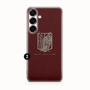Może przedstawiać: Bordowa obudowa telefonu z przezroczystą obw&oacute;dką. Obudowa posiada srebrny emblemat z napisem "SCOUTING LEGION". Emblemat to stylizowany wz&oacute;r skrzydeł i tarczy.