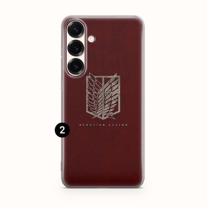 Może przedstawiać: Bordowa obudowa telefonu z przezroczystą obw&oacute;dką. Obudowa posiada srebrny emblemat z napisem "SCOUTING LEGION". Emblemat to stylizowany wz&oacute;r skrzydeł i tarczy.