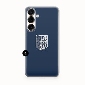 Może przedstawiać: Granatowe etui na telefon z białym emblematem ze stylizowanymi skrzydłami. Etui ma przezroczystą obw&oacute;dkę i zestaw aparat&oacute;w po lewej stronie u g&oacute;ry. Emblemat pochodzi z anime Atak Tytan&oacute;w.