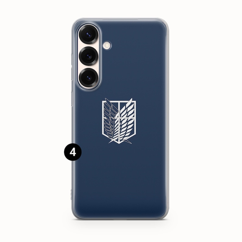 Może przedstawiać: Granatowe etui na telefon z białym emblematem ze stylizowanymi skrzydłami. Etui ma przezroczystą obw&oacute;dkę i zestaw aparat&oacute;w po lewej stronie u g&oacute;ry. Emblemat pochodzi z anime Atak Tytan&oacute;w.