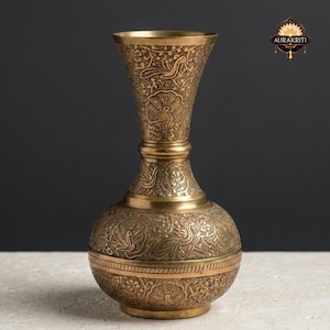 Könnte beinhalten: Eine Messingvase mit aufwendigen Gravuren von Blumen und Vögeln. Die Vase hat einen bauchigen Boden, einen schlanken Hals und eine ausgestellte Öffnung. Die detaillierten Schnitzereien und warmen Metalltöne erzeugen eine antike Ästhetik.