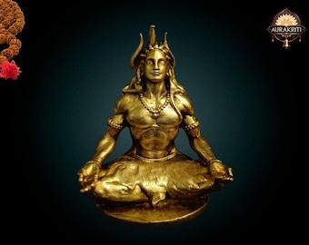 May include: A gold-colored statue of a seated deity in a meditative pose. The figure has a serene expression, adorned with jewelry and a crown. The statue is on a round base against a dark teal background.
