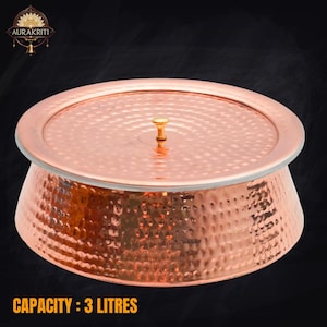 May include: A copper serving bowl with a lid. The bowl has a hammered texture and a capacity of 3 litres. The lid has a small, gold-coloured handle. The bowl is designed for serving food.