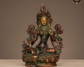 May include: A bronze statue of a seated deity, featuring detailed craftsmanship. The figure is adorned with a crown and jewellery, with a calm expression. The statue has a green patina, giving it an aged look. The base is decorated with floral patterns.