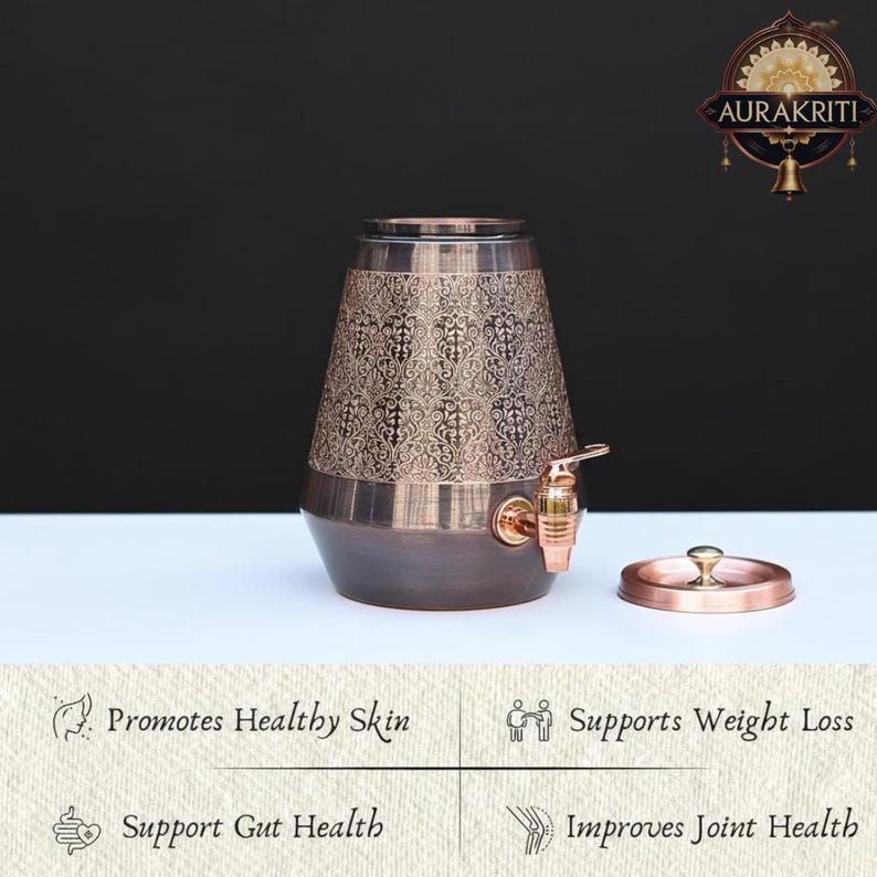 May include: A copper-colored water dispenser with an ornate floral pattern on the upper portion. It features a spigot and a lid. The dispenser is on a white surface with a dark background. The image also includes text that says "Promotes Healthy Skin" and "Supports Weight Loss."