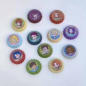 Peut inclure: Plusieurs capsules de bouteilles colorées avec des illustrations de personnages de dessins animés. Chaque capsule porte un nom de personnage différent, comme Penny, Sebastian et Elliott, avec le texte "Stardew Valley" sur les bords. Les capsules sont de différentes couleurs, dont le rouge, le vert et le violet.