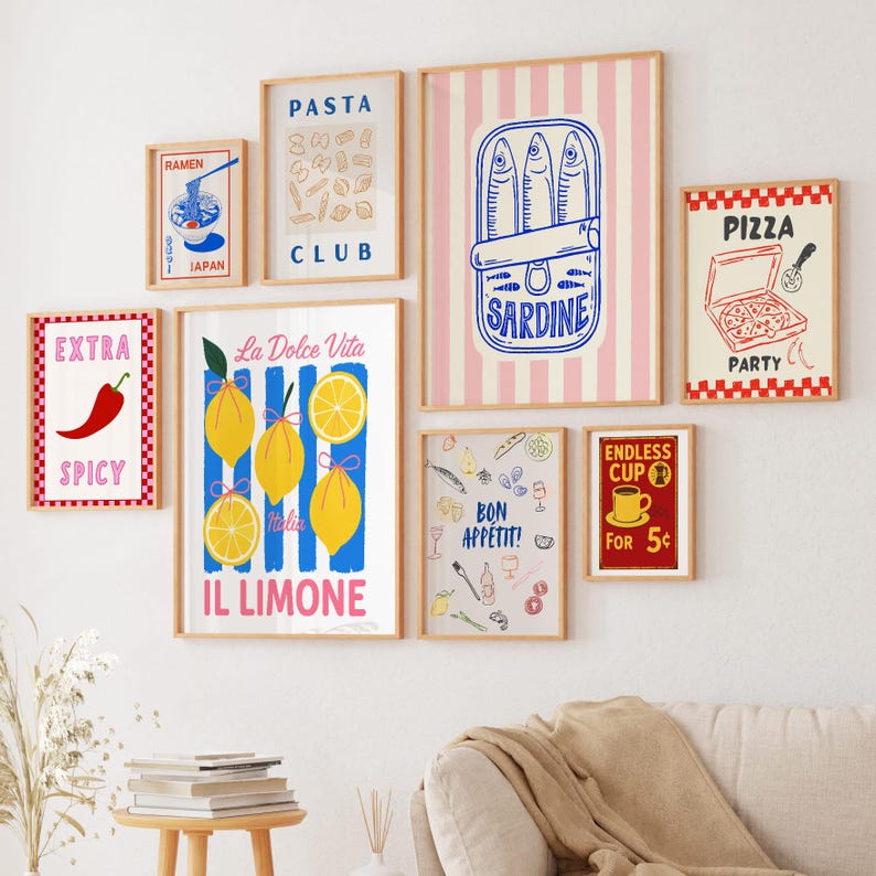 May include: A collection of framed art prints with a food theme. Prints include images of ramen, pasta, sardines, pizza, lemons, and a chili pepper. The prints are in various sizes and feature bold colors and text.