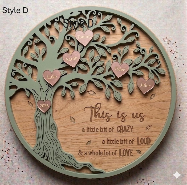 May include: A wooden family tree wall decor with a light green tree design and pink heart-shaped name tags. The text "This is us" and other phrases are engraved on the wooden background. The tree is set in a round frame.