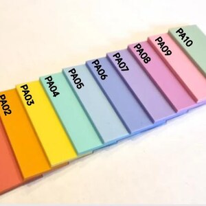 May include: A color palette of ten rectangular acrylic paint swatches in a gradient of colors, from coral to light green. Each swatch is labeled with "PA" followed by a number. The palette is arranged diagonally.