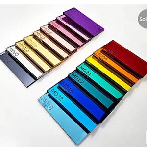 May include: A collection of rectangular acrylic color swatches in various shades, including black, white, gold, pink, purple, red, orange, yellow, green, and blue. Each swatch is labeled with a code. The image shows a 'Sold out' label.