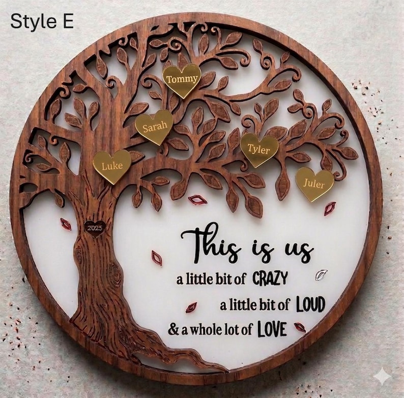 May include: A round wooden family tree wall decor with a dark brown finish. The tree has gold heart-shaped name tags and the text "This is us" with the phrases "a little bit of CRAZY, a little bit of LOUD, & a whole lot of LOVE."