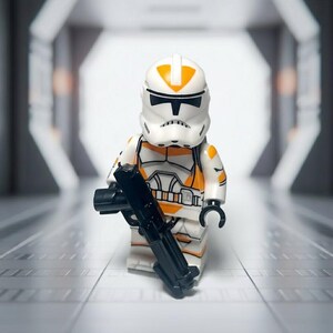 May include: A Lego minifigure of a clone trooper, featuring a white and orange color scheme. The figure is holding a black blaster rifle. The trooper's helmet has orange markings. The background is a blurred, futuristic corridor.