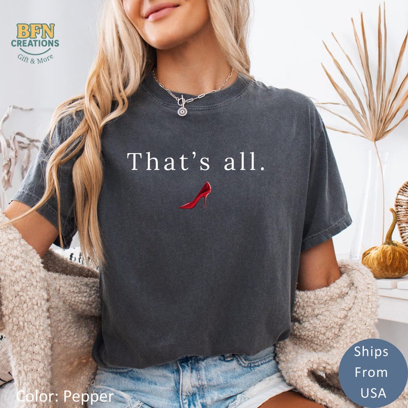May include: Dark gray t-shirt with the text "That's all." and a red high heel graphic. The shirt is a relaxed fit and has a crew neck. The color is Pepper.