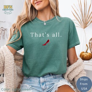 May include: Light green t-shirt with the text "That's all." and a red high heel graphic. The shirt has a relaxed fit and is made of a soft material. The shirt is a light green color.